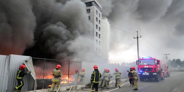 Firefighters work to extinguish a fire at a damaged logistic center after shelling in Kyiv, Ukraine, Thursday, March 3, 2022. (AP Photo/Efrem Lukatsky)