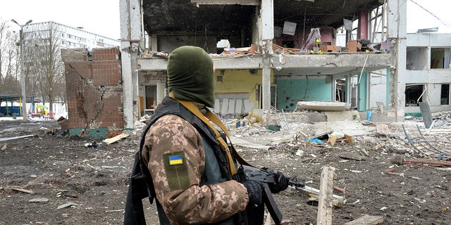 A member of the Ukrainian Territorial Defence Forces looks at destructions following a shelling in Ukraine's second-biggest city of Kharkiv on March 8, 2022.