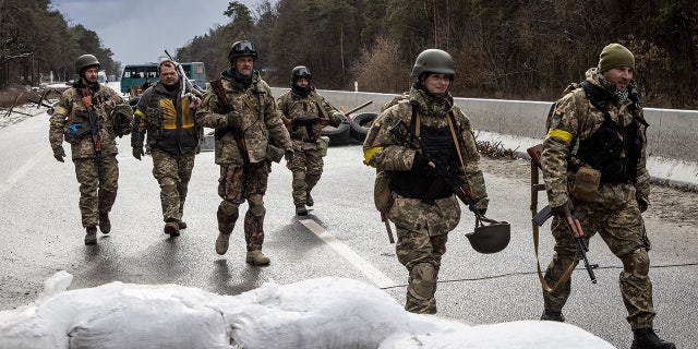 Members of the Ukrainian military arrive to reinforce a forward position on the eastern frontline near Kalynivka village on March 8, 2022, in Kyiv, Ukraine.