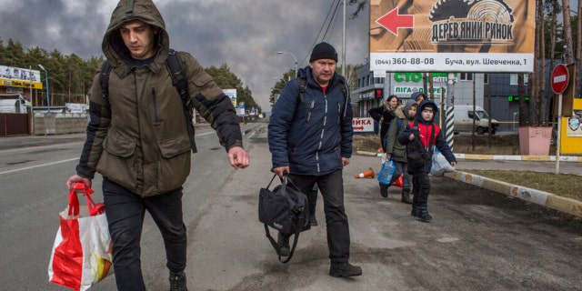 People leave the town of Bucha, close to Kyiv, Ukraine, Friday, March 4, 2022.