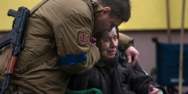 A soldier comforting Larysa Kolesnyk, 82, after being evacuated from Irpin on the outskirts of Kyiv, Ukraine, March 30.
