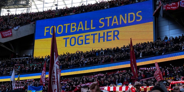 A video screen displays the Ukrainian flag during the English League Cup final soccer match between Chelsea and Liverpool at Wembley Stadium in London Feb. 27, 2022.