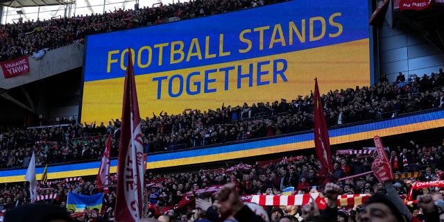 Un écran vidéo affiche le drapeau ukrainien, lors du match de football final de la Coupe de la Ligue anglaise entre Chelsea et Liverpool au stade de Wembley à Londres, dimanche 27 février 2022.