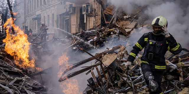 Responders are seen at the scene after a building destroyed by a Russian rocket attack in downtown Kharkiv
