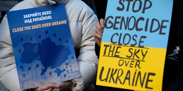 Two women hold posters during a demonstration outside the embassy of France in Lisbon in solidarity with the Ukrainian people, Friday, March 4, 2022. Demonstrations were organized outside a number of embassies Friday.