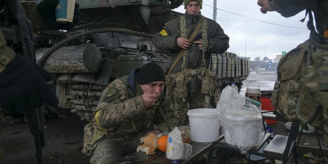 Service members of the Ukrainian armed forces gather at their positions outside the settlement of Makariv, amid the Russian invasion of Ukraine, near Zhytomyr, Ukraine March 4, 2022.