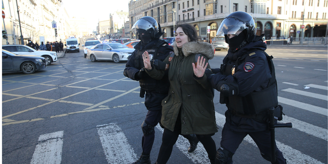 Russian police officers detain a woman during an unsanctioned protest rally against the military invasion of Ukraine, March 6, 2022, in Moscow.