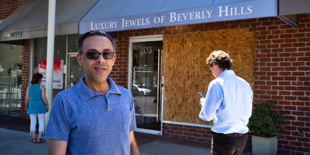 Owner Peter Sedghi stands on the street in front of his boarded up shop, Luxury Jewels of Beverly Hills on Wednesday, March 23, 2022, in Beverly Hills, Calif. 