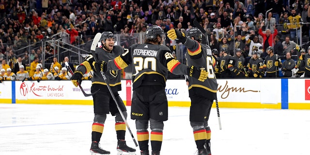 Vegas Golden Knights defenseman Shea Theodore (27), center Chandler Stephenson (20) and right wing Evgenii Dadonov (63) celebrate Dadonov's goal against the Nashville Predators during the second period of an NHL hockey game Thursday, Maart 24, 2022, in Las Vegas.