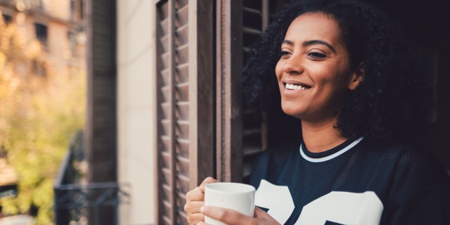 Woman drinking coffee with a smile.