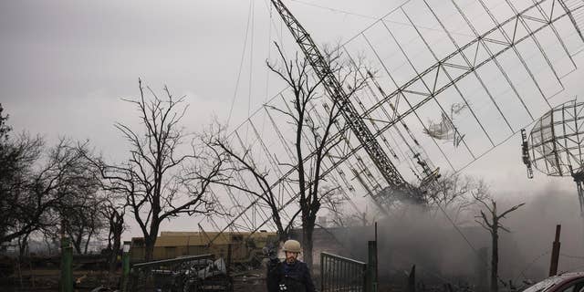 Associated Press videographer Mstyslav Chernov walks amid smoke rising from an air defense base in the aftermath of a Russian strike in Mariupol, Ukraine, Feb. 24, 2022. (AP Photo/Evgeniy Maloletka)