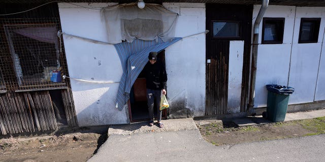 Hasib Qarizada leaves a shop in the Krnjaca refugee center near Belgrade, Serbia, Thursday, Feb. 24, 2022.