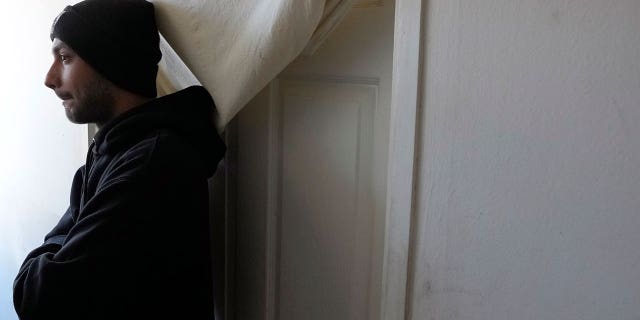 Hasib Qarizada, a student from Afghanistan, stands outside his room in the Krnjaca refugee center near Belgrade, Serbia, Thursday, Feb. 24, 2022.