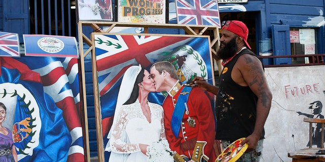 Artist Alex Sanker, 51, paints a picture of Britain's Prince William and his wife Catherine, in a street of Belize City, 在三月 18, 2022, the day ahead of their visit. 