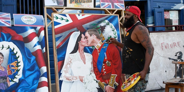 Artist Alex Sanker, 51, paints a picture of Britain's Prince William and his wife Catherine, in a street of Belize City, 在三月 18, 2022, the day ahead of their visit.