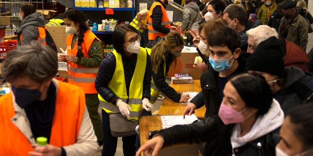 Refugees from the Ukraine get relief goods from volunteers after they arrive at the main train station in Berlin, Germany, Tuesday, March 15, 2022.