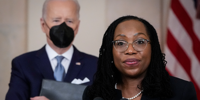 President Joe Biden looks on as Judge Ketanji Brown Jackson delivers brief remarks.