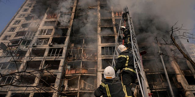 Firefighters climb a ladder while working to extinguish a blaze in a destroyed apartment building after a bombing in a residential area in Kyiv, Ukraine, Tuesday, March 15, 2022. Russia's offensive in Ukraine has edged closer to central Kyiv with a series of strikes hitting a residential neighborhood as the leaders of three European Union member countries planned a visit to Ukraine's embattled capital. 