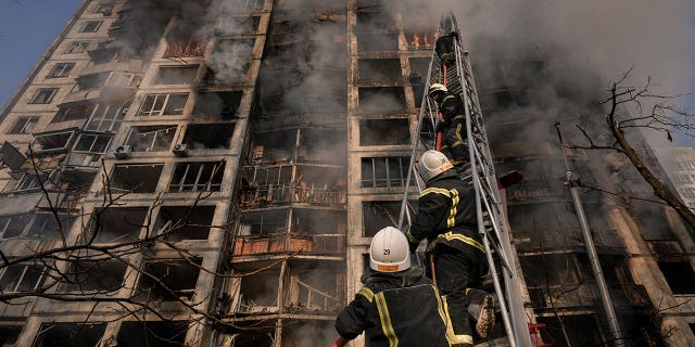 Firefighters climb a ladder while working to extinguish a blaze in a destroyed apartment building after a bombing in a residential area in Kyiv, Ukraine, Tuesday, March 15, 2022. Russia's offensive in Ukraine has edged closer to central Kyiv with a series of strikes hitting a residential neighborhood as the leaders of three European Union member countries planned a visit to Ukraine's embattled capital. 