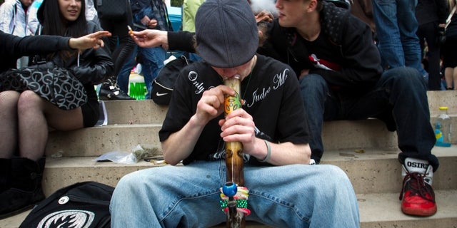 A teenager smokes marijuana out of a bong while with friends at the Vancouver Art Gallery during the annual 4/20 day, which promotes the use of marijuana, in Vancouver, British Columbia, April 20, 2013. 
