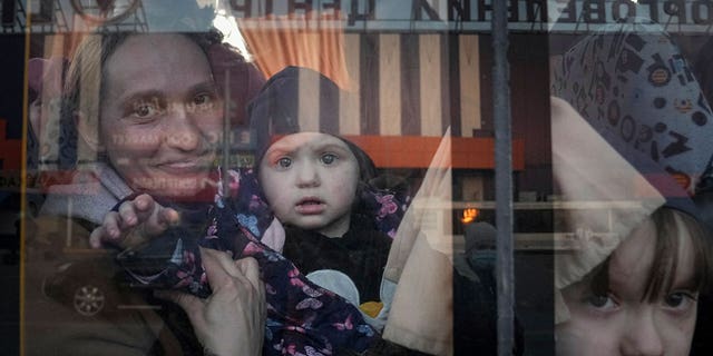 FILE - Internally displaced people look out from a bus at a refugee center in Zaporizhia, Ukraine, on March 25, 2022. The U.N. refugee agency says more than 4 million refugees have now fled Ukraine following Russia’s invasion, a new milestone in the largest refugee crisis in Europe since World War II. (AP Photo/Evgeniy Maloletka)
