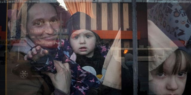 FILE - Internally displaced people look out from a bus at a refugee center in Zaporizhia, Ukraine, on March 25, 2022. The U.N. refugee agency says more than 4 million refugees have now fled Ukraine following Russia’s invasion, a new milestone in the largest refugee crisis in Europe since World War II. (AP Photo/Evgeniy Maloletka)