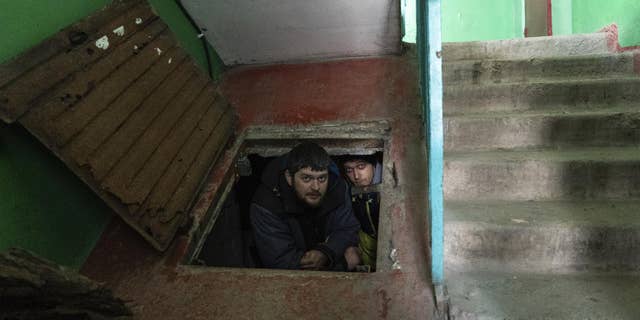 People hide in an improvised bomb shelter in Mariupol, Ukraine, March 12, 2022.