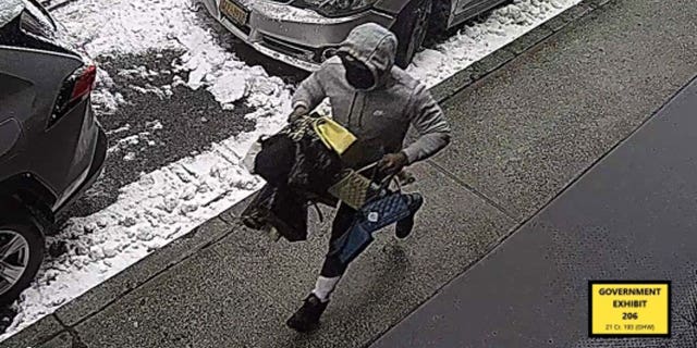 Spencer fleeing the SoHo store robbery with stolen merchandise.