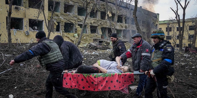 Ukrainian emergency employees and volunteers carry an injured pregnant woman from a maternity hospital damaged by shelling in Mariupol, Ukraine, Wednesday, March 9, 2022. The baby was born dead. Half an hour later, the mother died too. 