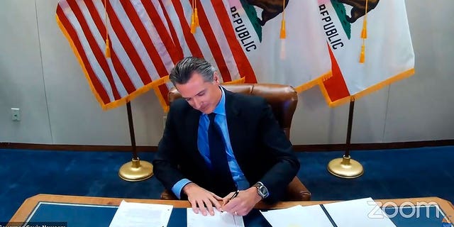 California Gov. Gavin Newsom signing a bill into law. 