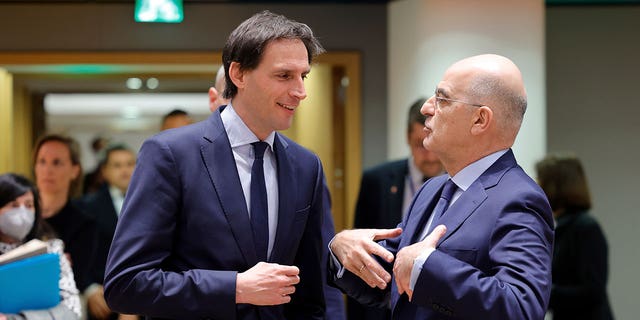 Dutch Foreign Minister Wopke Hoekstra, left, talks to Greek Foreign Minister Nikos Dendias during a meeting of EU foreign ministers at the Europa building in Brussels, Monday, March 21, 2022. 