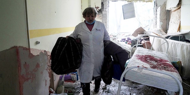 A medical worker walks inside a maternity hospital in Mariupol, Ukraine, damaged by shelling 