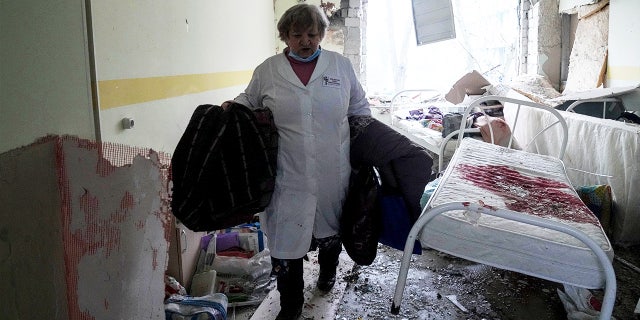 A medical worker walks inside a maternity hospital in Mariupol, Ukraine, damaged by shelling 