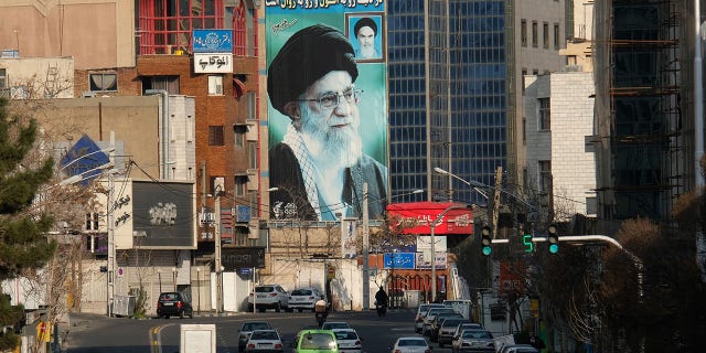 A giant mural of Ayatollah Sayyed Ali Khamenei, the Supreme Leader of Iran, painted next to a smaller mural of Ayatollah Ruhollah Khomeini (R) seen in Tehran, Iran.the message written on the wall "America's power, influence and dignity in the world are collapsing and being eradicated" Another slogan is written on the building "we stand till the end".