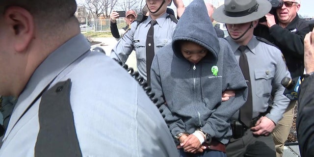 Jayana T. Webb escorted by police while being taken into custody.