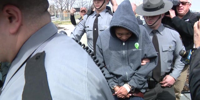 Jayana T. Webb escorted by police while being taken into custody.