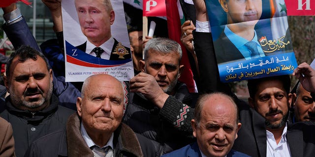 People hold portraits of President Vladimir Putin and Syrian President Bashar Assad during a demonstration in support of Russia's invasion of Ukraine, in Beirut, Lebanon, Sunday, March 20, 2022.