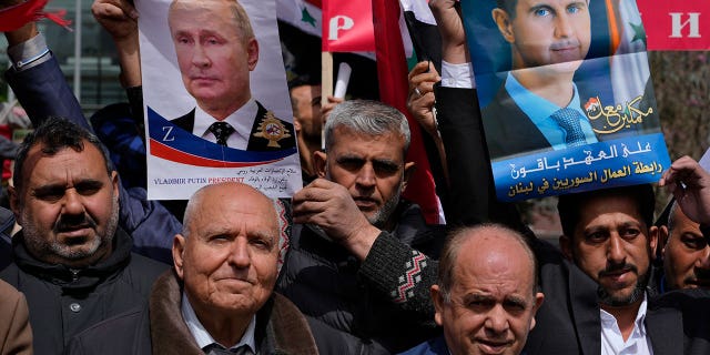 People hold portraits of President Vladimir Putin and Syrian President Bashar Assad during a demonstration in support of Russia's invasion of Ukraine, in Beirut, Lebanon, Sunday, March 20, 2022.