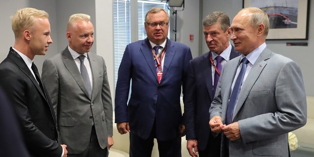 Nikita and Dmitry Mazepin (L) met with Russian President Putin (R) on the sidelines of the Russian Grand Prix in Sochi in 2018.