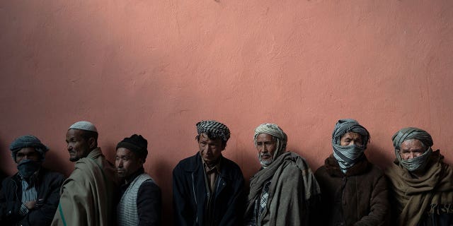 A man waits in line to receive cash at a cash distribution organized by the World Food Program in Kabul, Afghanistan, November 3, 2021.