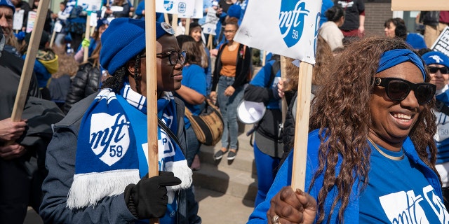 Minneapolis teachers walk the picket line on the 10th day of the teachers strike in front of the Davis Center in Minneapolis, Monday, March 21, 2022.