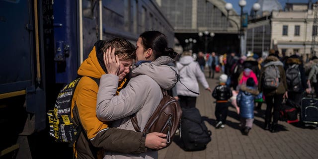 A mother embraces her son who escaped the besieged city of Mariupol and arrived at the train station in Lviv, western Ukraine, on Sunday, March 20, 2022.