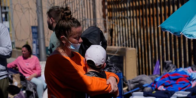 A Russian woman hugs her son as they wait near the San Ysidro Port of Entry leading into the United States on March 17, 2022.