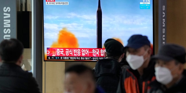 People watch a TV showing a file image of North Korea's missile launch during a news program at the Seoul Railway Station in Seoul, South Korea, Thursday, March 24, 2022.
