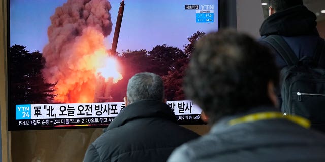 People watch a news program showing a file image of North Korea's rocket launch, at the Seoul Railway Station in Seoul, South Korea, Sunday, March 20, 2022. (AP Photo/Ahn Young-joon)