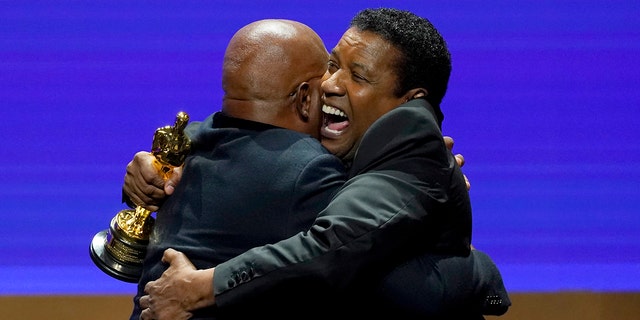 Denzel Washington, right, presents Samuel L. Jackson with an honorary Oscar at the Governors Awards on Friday, March 25, 2022, at the Dolby Ballroom in Los Angeles. 