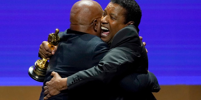 Denzel Washington, a la derecha, entrega a Samuel L. Jackson un Oscar honorífico en los Premios de los Gobernadores el viernes 25 de marzo de 2022 en el Dolby Ballroom de Los Ángeles. 