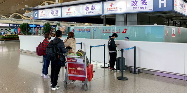 Passengers check in at the China Eastern Airlines rebook counter following a state media report that all 737-800s in China Eastern's fleet were ordered grounded, at the Kunming airport, in southwestern China's Yunnan province, Tuesday, March 22, 2022.