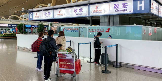I passeggeri effettuano il check-in allo sportello prenotazioni della China Eastern Airlines a seguito di un resoconto dei media statali secondo cui tutti i 737-800 della flotta della China Eastern sono stati bloccati all'aeroporto di Kunming, nella provincia dello Yunnan nella Cina sudoccidentale, martedì 22 marzo 2022.