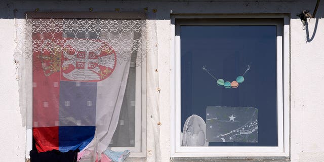 A Serbian flag is seen on a window in the Krnjaca refugee center near Belgrade, Serbia, Thursday, Feb.  24, 2022.